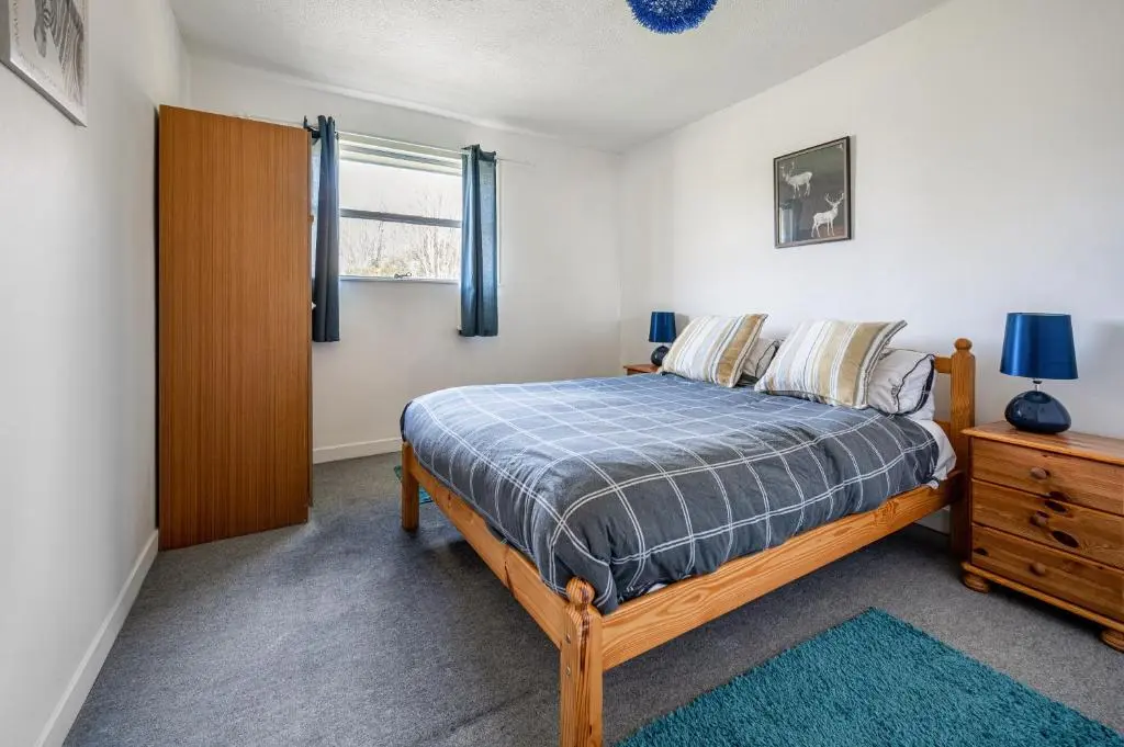 a bedroom with a bed and a dresser and a window at 2 Bed Chalet - Sleeps 4 - River and mountain views in Strathpeffer