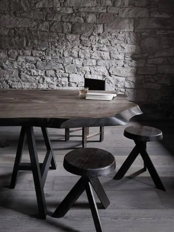 a wooden table with two stools in front of a brick wall at Luxury lodge for 16 in Royal Deeside in Ballater