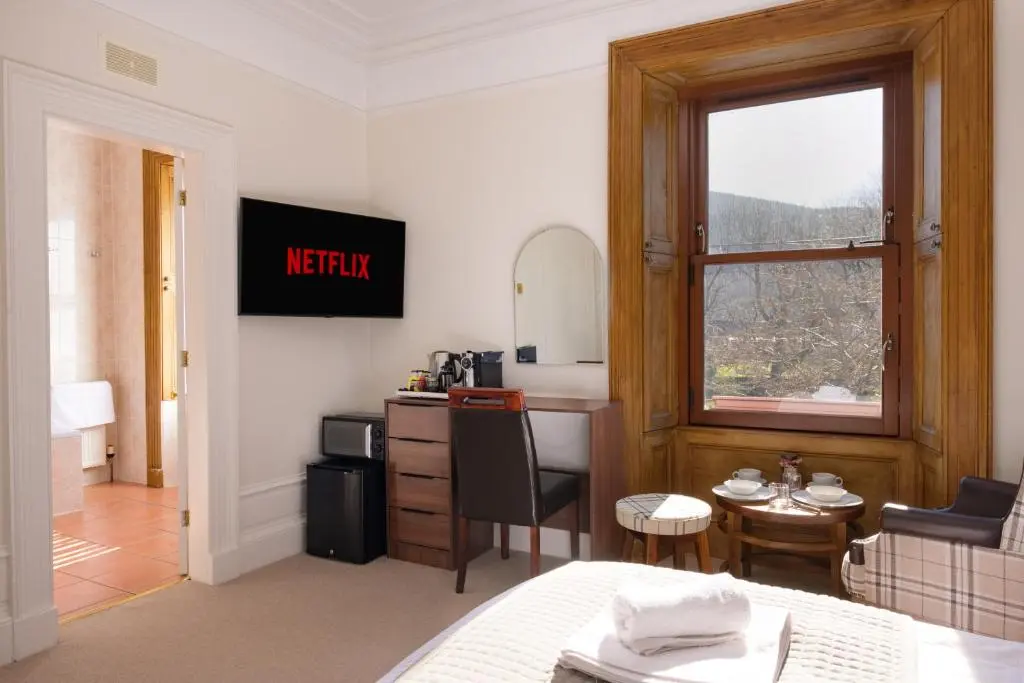 a hotel room with a kitchen and a window at Netherley Rooms in Ballater