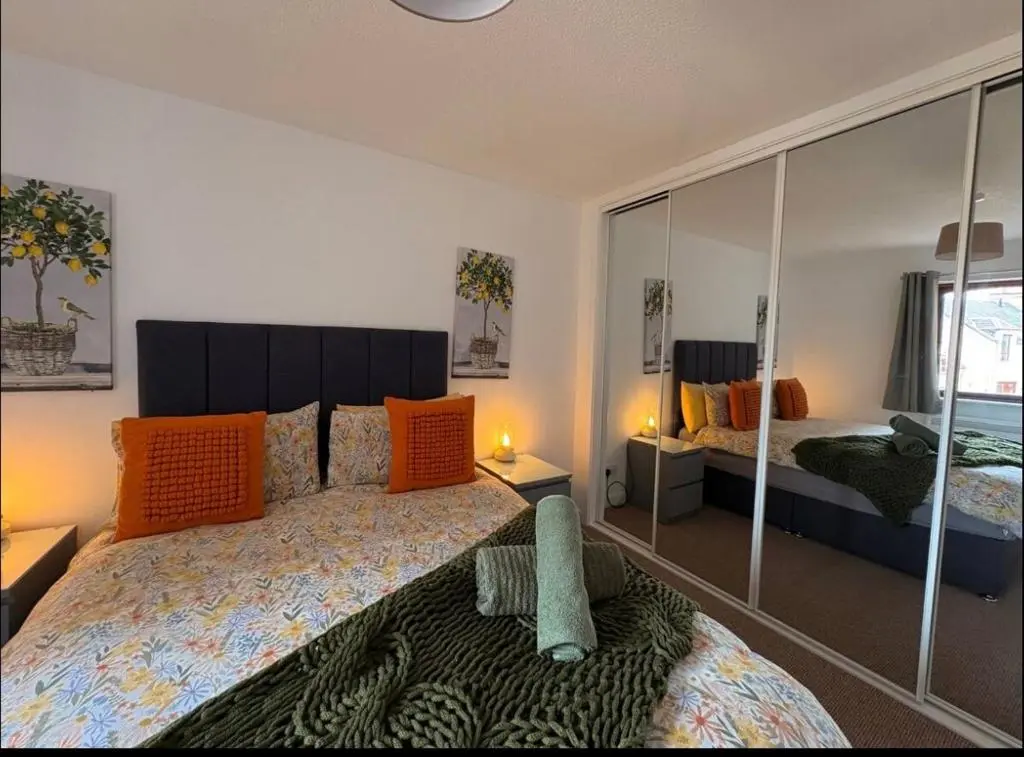a bedroom with two beds with orange pillows at Elegant Apartment In City Centre in Inverness