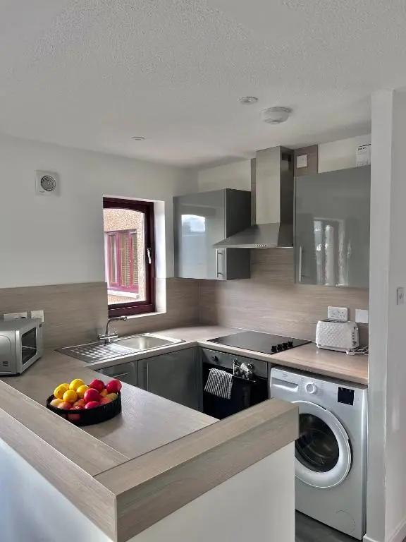 a kitchen with a bowl of fruit on a counter at Elegant Apartment In City Centre in Inverness