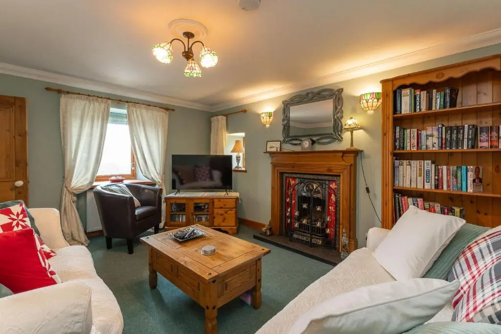 a living room with a couch and a fire place at Fishermans Cottage in Lossiemouth