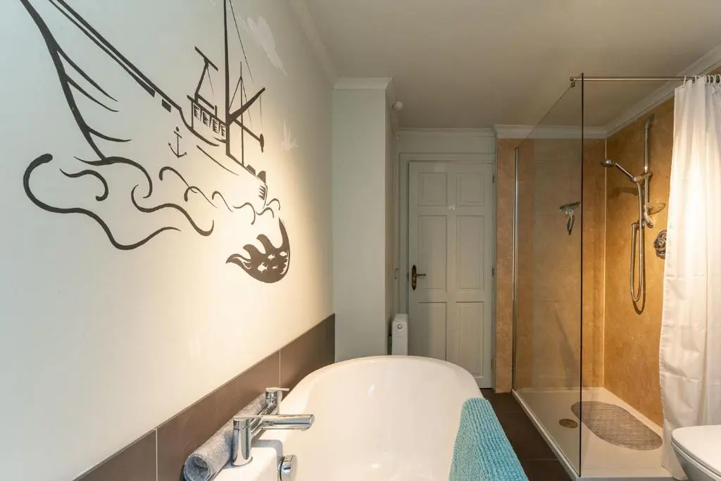 a bathroom with a bath tub and a shower at Fishermans Cottage in Lossiemouth