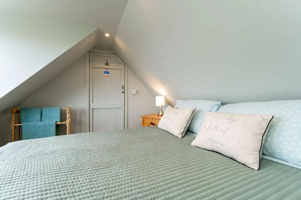 a bedroom with a bed with two pillows on it at Fishermans Cottage in Lossiemouth