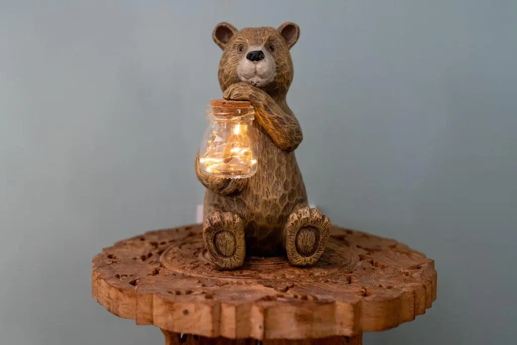 a figurine of a bear holding a jar on a stump at Fishermans Cottage in Lossiemouth