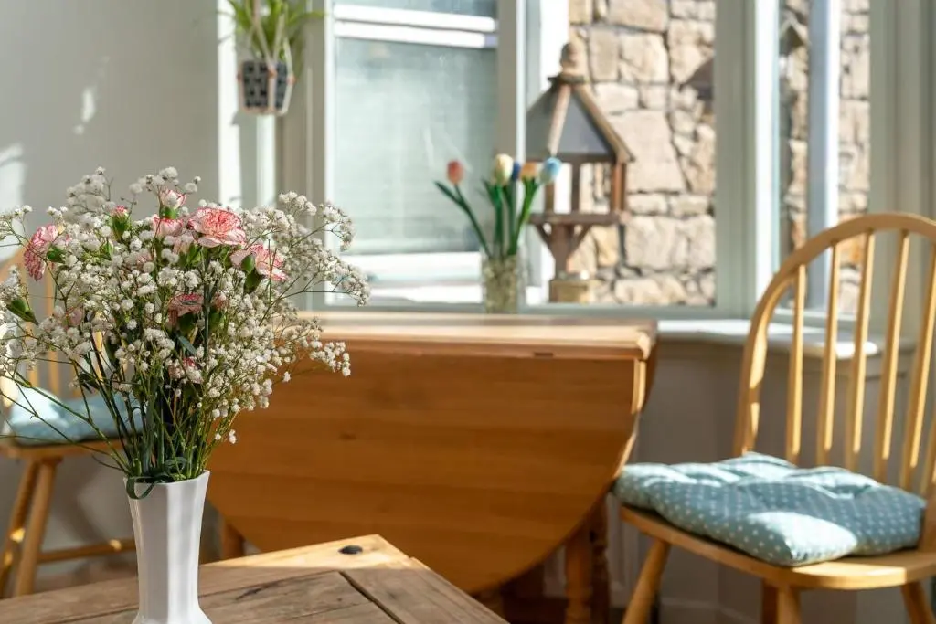 a table with a vase of flowers on a table at Fishermans Cottage in Lossiemouth
