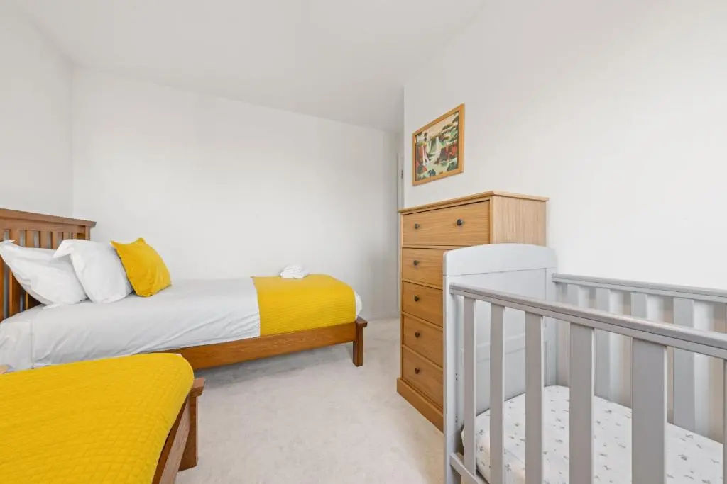 a bedroom with two beds and a crib at Pinewood 3 Bedroom House in Inverness with Views in Inverness