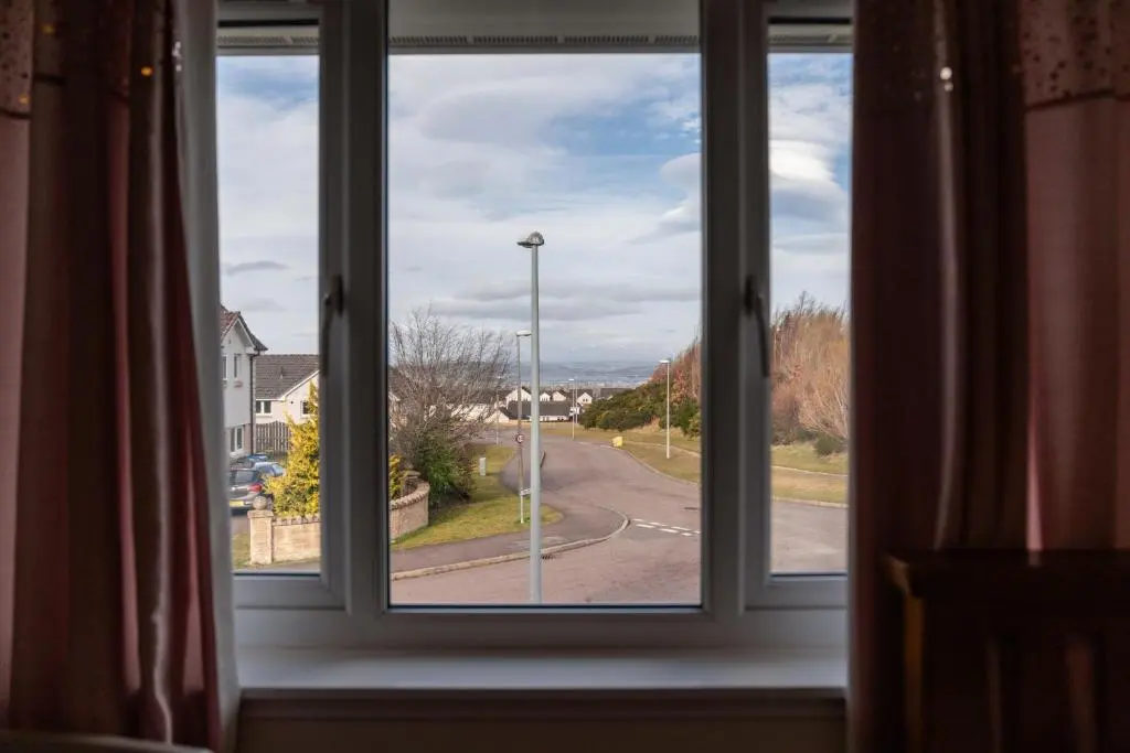 an open window with a view of a street at Pinewood 3 Bedroom House in Inverness with Views in Inverness