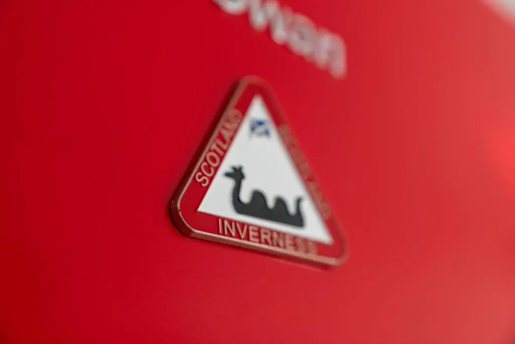 a sign on the side of a red car at Pinewood 3 Bedroom House in Inverness with Views in Inverness