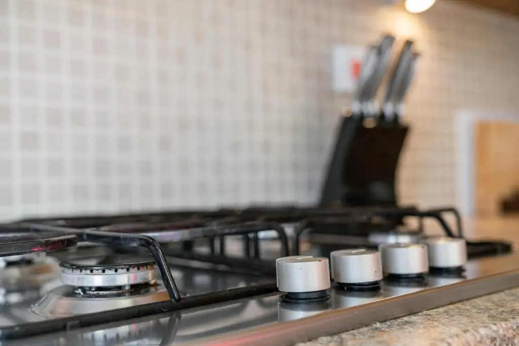 a stove top with white cups on top of it at Pinewood 3 Bedroom House in Inverness with Views in Inverness