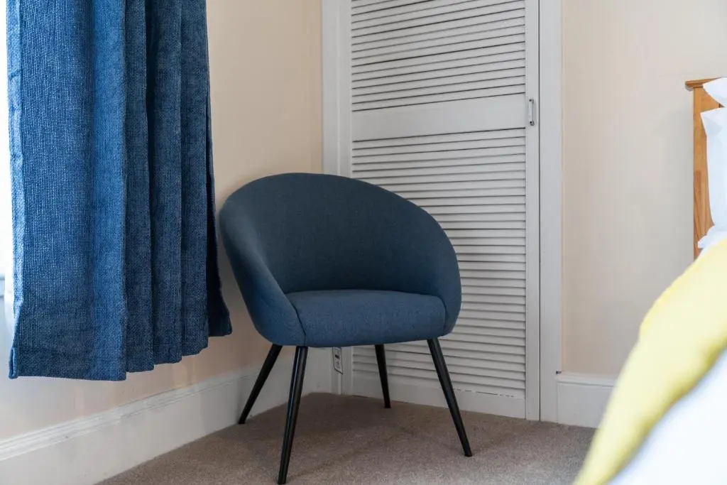 a blue chair sitting in a bedroom next to a window at Central 1 Bedroom Apartment - Inverness in Inverness