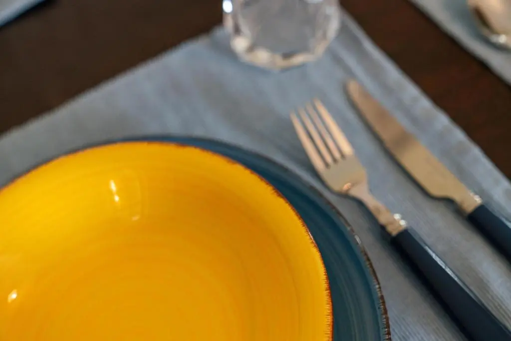 a yellow plate with a fork and knife on a table at Central 1 Bedroom Apartment - Inverness in Inverness