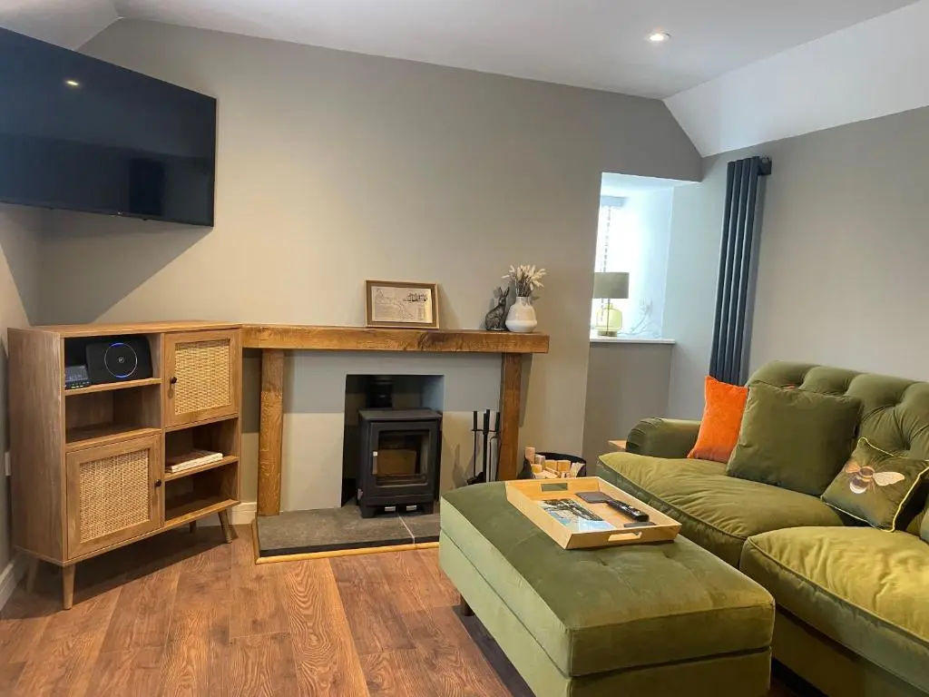a living room with a couch and a fireplace at Struie Bothy near Dornoch Beach in Dornoch