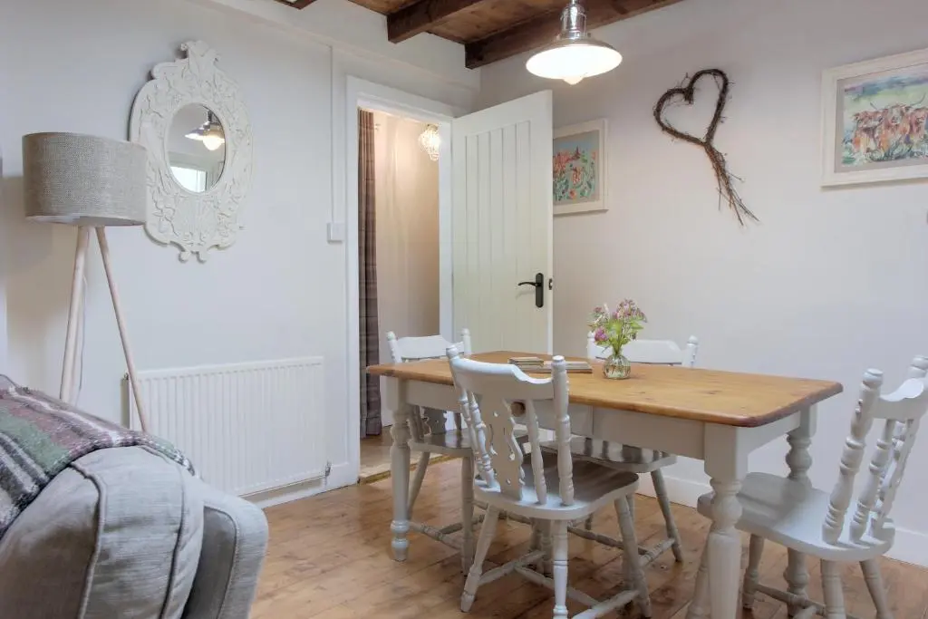 a dining room with a wooden table and chairs at Bridge Cottage in Glenlivet