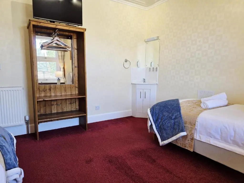 a room with two beds and a television on the wall at Inverness City 4 Bedroom house free parking in Inverness