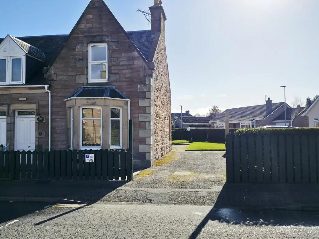 a brick house with a black fence in front of it at Inverness City 4 Bedroom house free parking in Inverness