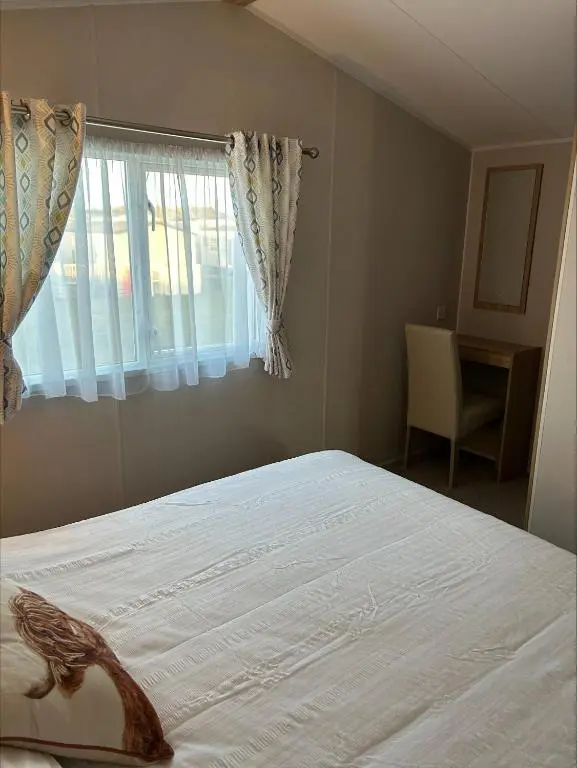 a bedroom with a large bed with a window at Silversands holiday park new caravan in Lossiemouth