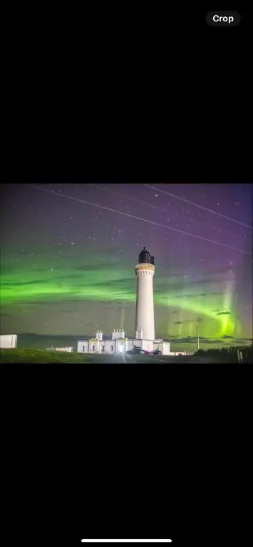 an image of a lighthouse with the green northern lights at Silversands holiday park new caravan in Lossiemouth