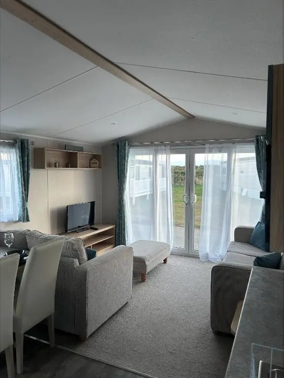 a living room with a couch and chairs and a tv at Silversands holiday park new caravan in Lossiemouth