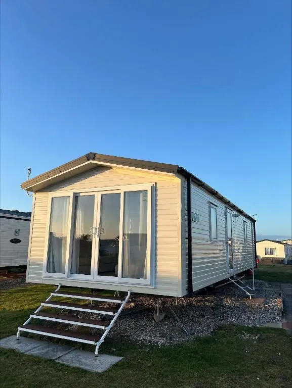 a tiny house is sitting on the grass at Silversands holiday park new caravan in Lossiemouth
