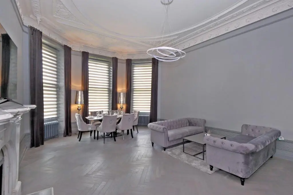 a large living room with a table and chairs at Kirkton House in Kirkton of Skene