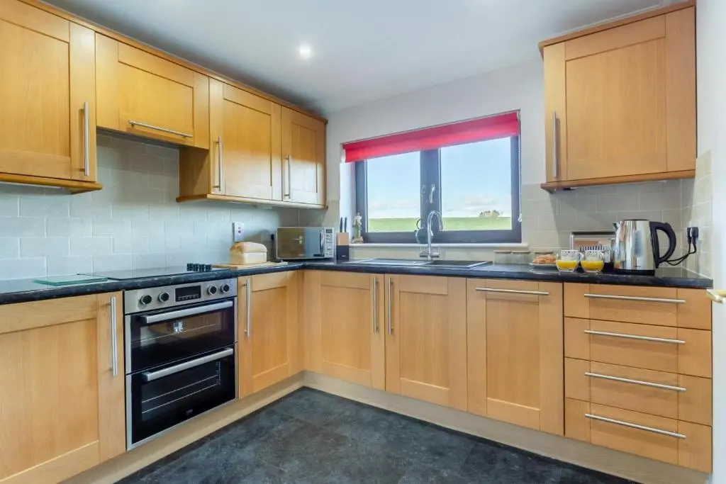 a large kitchen with wooden cabinets and a window at 2 Bed in Insch oc-t30986 in Colpy