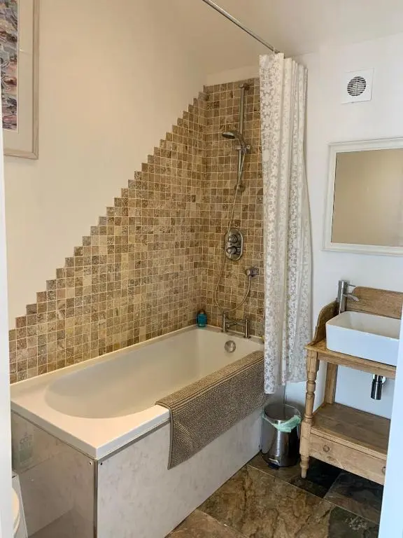 a bathroom with a bath tub and a sink at The Space at the Creamery - Royal Deeside in Torphins