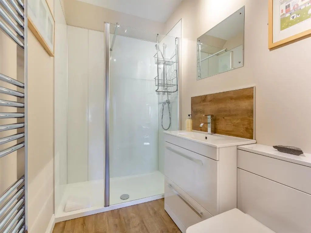 a white bathroom with a shower and a sink at Harbour View in Cromarty