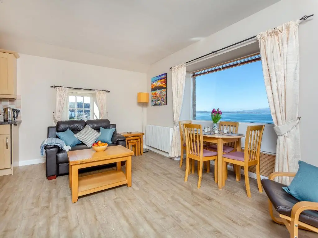 a living room with a couch and a table at Harbour View in Cromarty