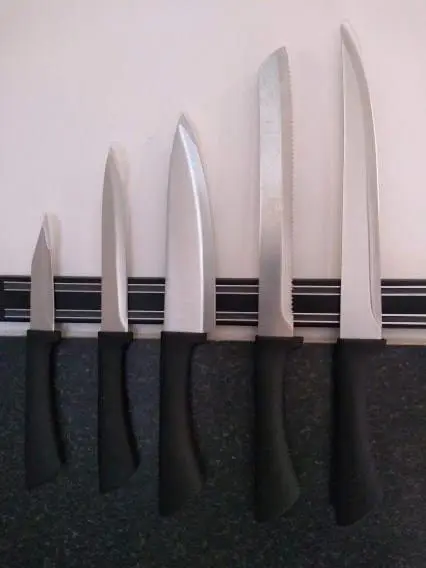 a row of knives hanging on a wall at True North Lodge - A cosy wee highland Getaway in Spean Bridge