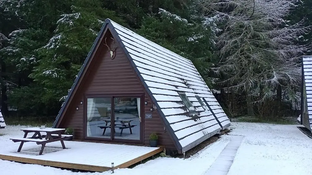 a small cabin with a picnic table in the snow at True North Lodge - A cosy wee highland Getaway in Spean Bridge