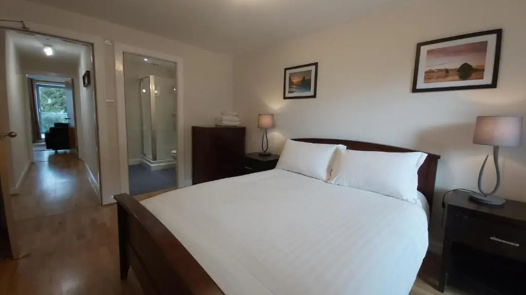 a bedroom with a large white bed in a room at Highland Club Scotland Apartments in Fort Augustus