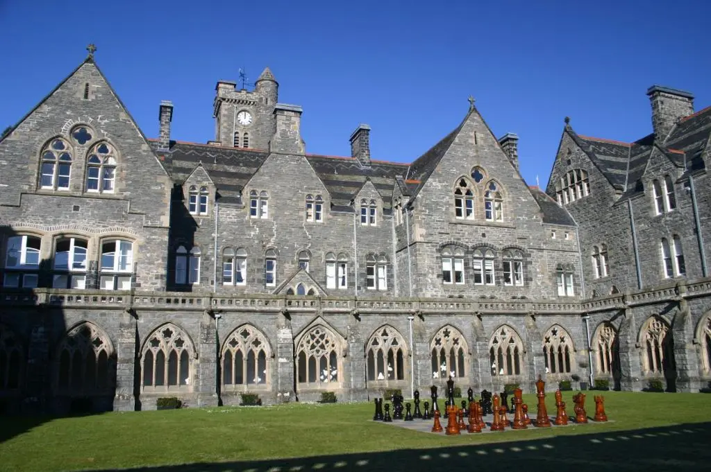 a large building with people standing in front of it at Highland Club Scotland Apartments in Fort Augustus
