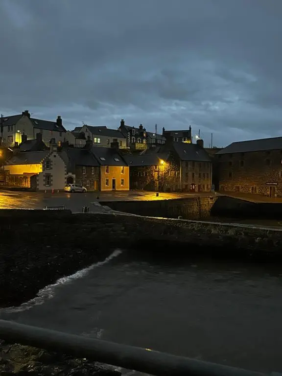 a group of buildings in a city at night at Cozy Cottage Retreat in Portsoy
