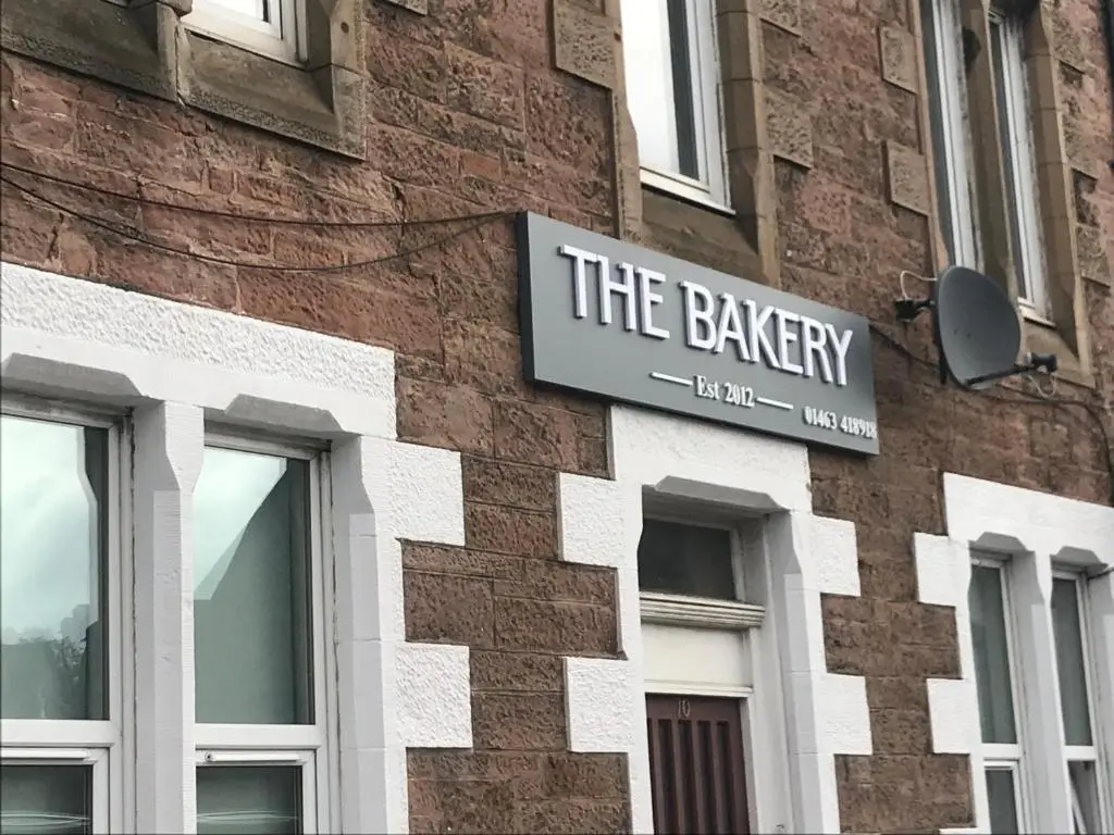 a sign on the side of a brick building at Butterfly Apartment in Inverness
