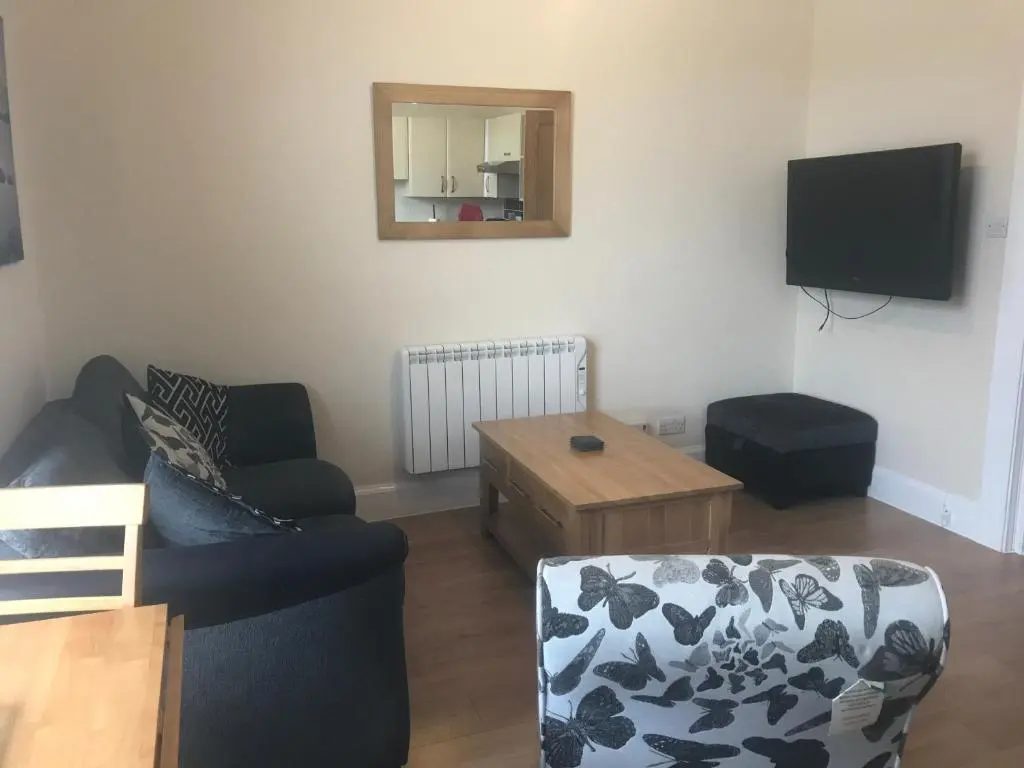 a living room with a couch and a tv at Butterfly Apartment in Inverness