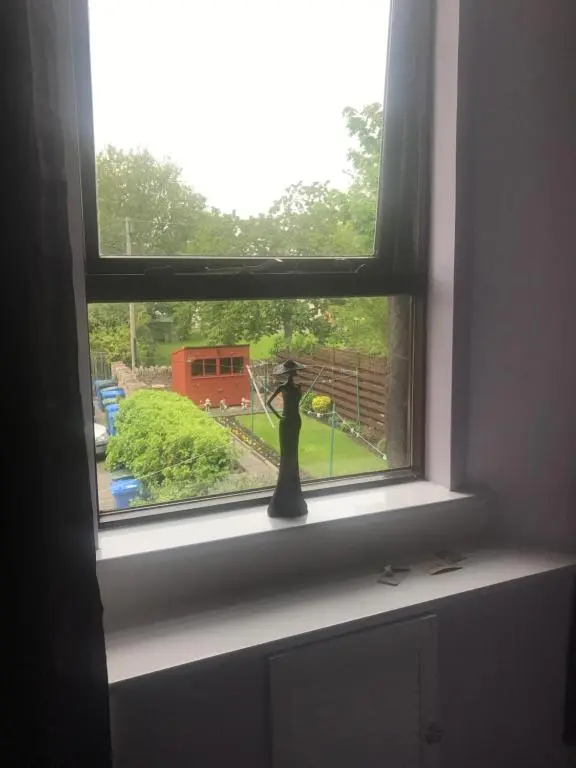 a window with a statue in the middle of it at Butterfly Apartment in Inverness