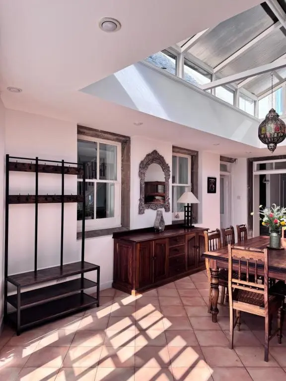 a conservatory with a table and a dining room at 19th century 5-bedroom villa with free private parking in Elgin