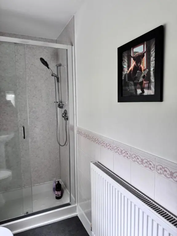 a bathroom with a shower and a picture on the wall at 19th century 5-bedroom villa with free private parking in Elgin