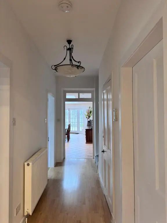 a hallway with white walls and a ceiling with a chandelier at 19th century 5-bedroom villa with free private parking in Elgin