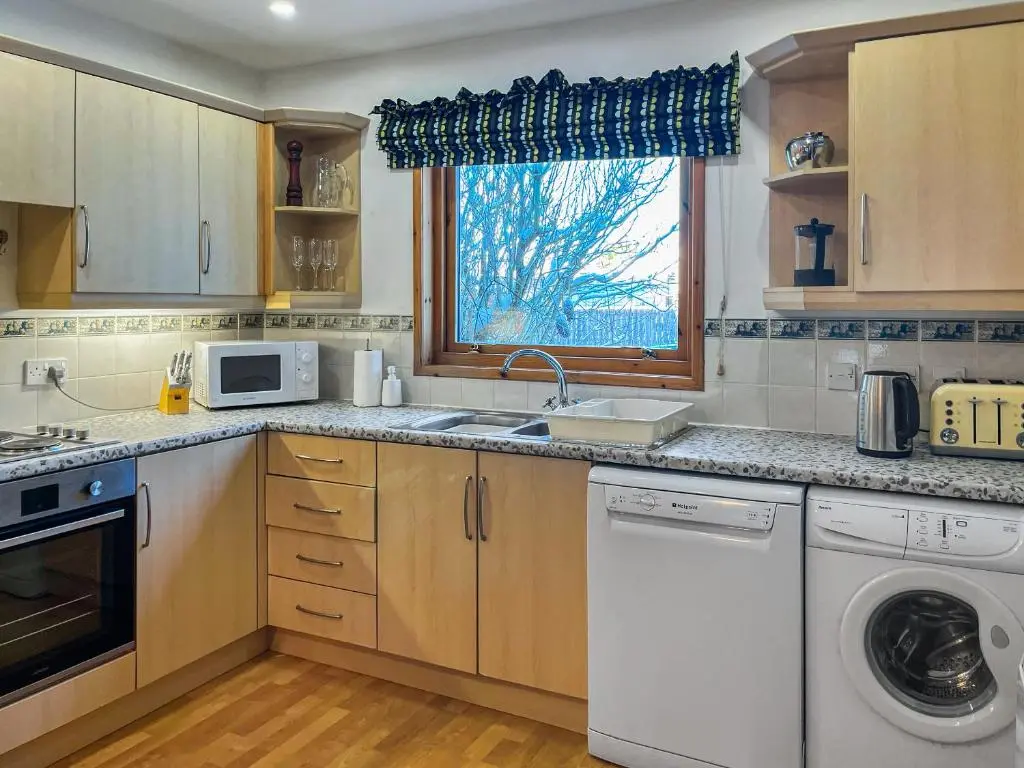 a kitchen with a sink and a dishwasher at Heath Cottage in Boat of Garten
