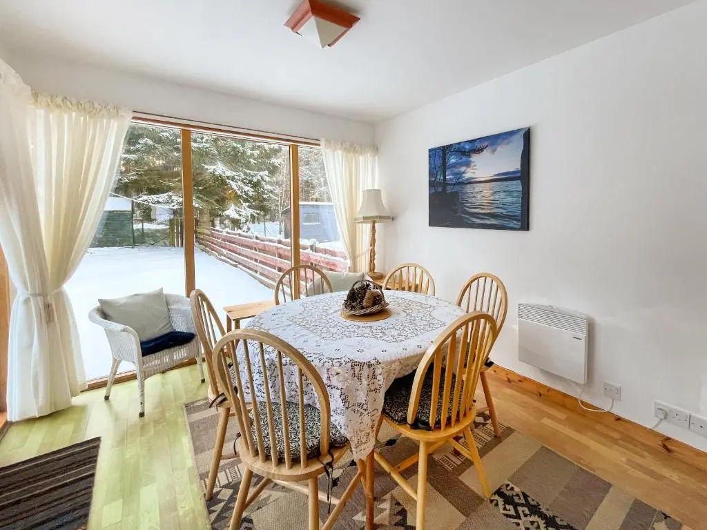 a dining room with a table and chairs at Heath Cottage in Boat of Garten