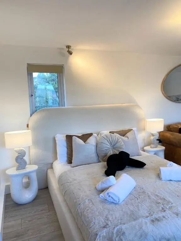a large white bed with a black dog laying on it at Kaoglen - Alpine Pod - Hot Tub - Cairngorms - Pitlochry in Kirkmichael