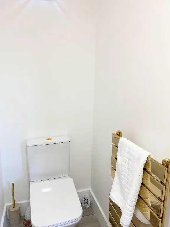 a bathroom with a white toilet and a chair at Kaoglen - Alpine Pod - Hot Tub - Cairngorms - Pitlochry in Kirkmichael