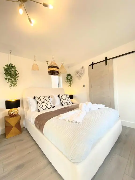 a white bedroom with a large white bed with pillows at Kaoglen - Bali Pod - Hot Tub -Cairngorms - Pitlochry in Kirkmichael