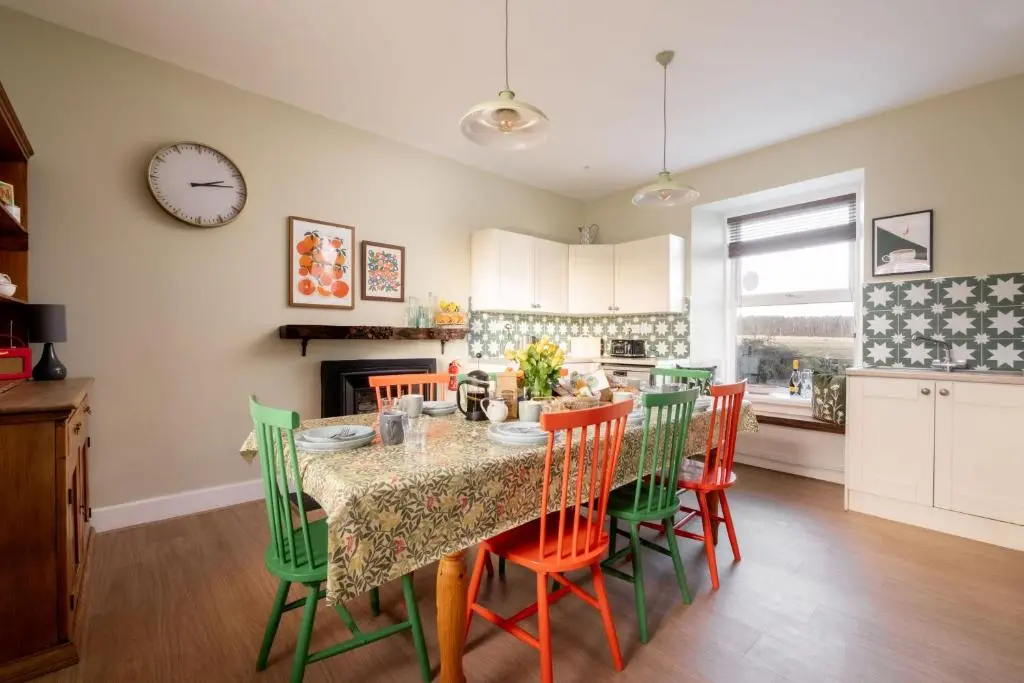 a kitchen and dining room with a table and chairs at Old Duffus Farmhouse in Duffus