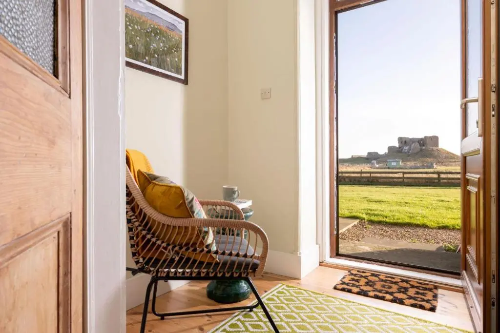 a wicker chair sitting in front of a door at Old Duffus Farmhouse in Duffus
