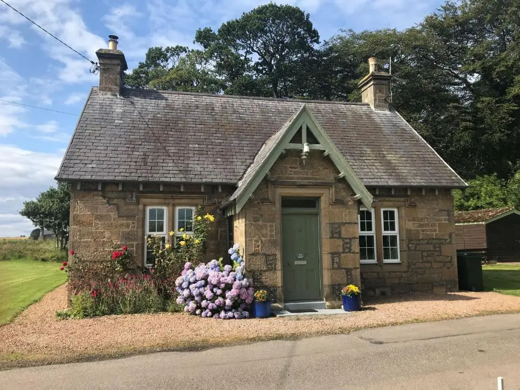 a small house with flowers in front of it at Duffus House Lodge in Duffus