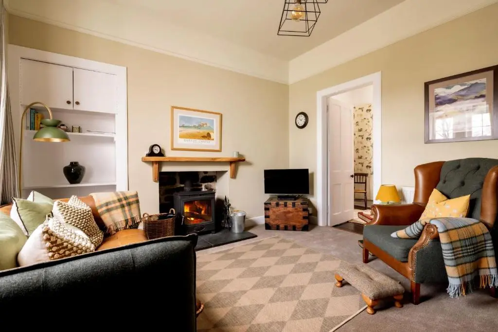 a living room with a couch and a fireplace at Duffus House Lodge in Duffus