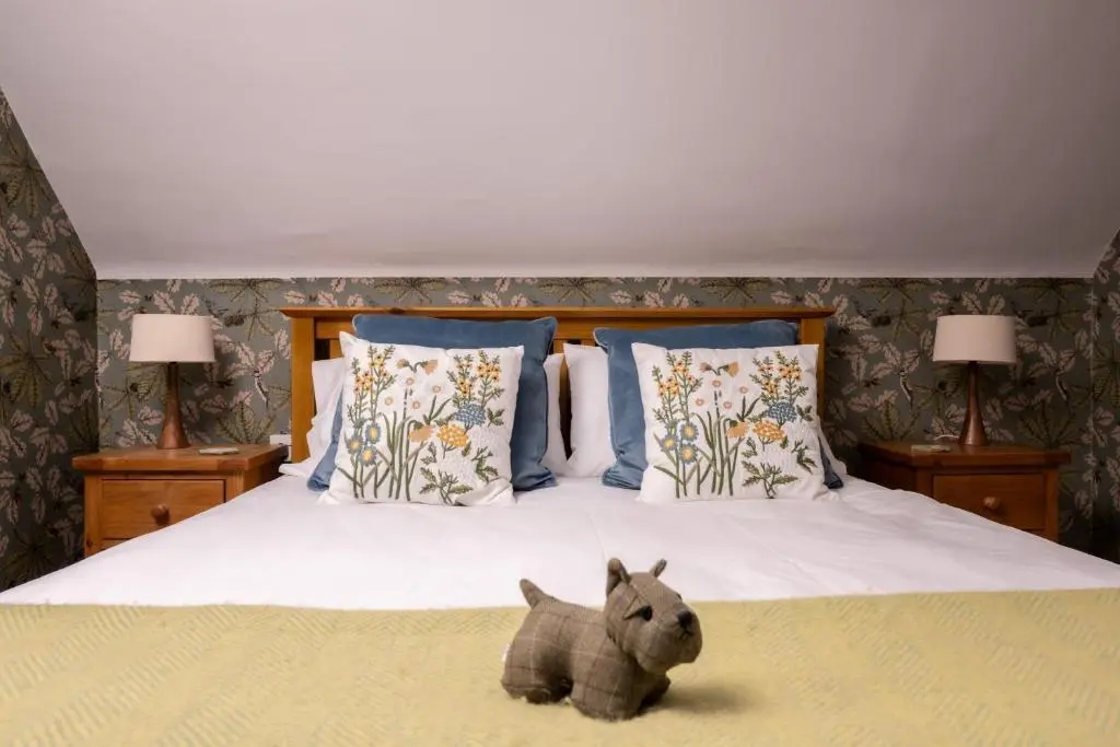 a stuffed animal sitting on top of a bed at Kirktoun Cottage in Duffus
